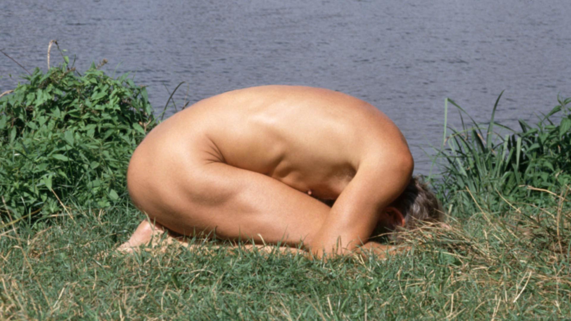 fkk - jung, nackt und frei - Nackt-Yoga - Variation von Garbhasana - Stellung des Kindes